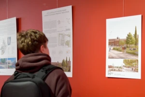 Vaikinas prekybos centre apžiūrinėja KTU architektūros magistrų baigiamųjų darbų parodą